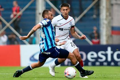 Gabriel Rojas, lateral izquierdo de San Lorenzo, intenta un ataque ante el bloqueo de Renzo Tesuri, uno de los cinco defensores de Atlético Tucumán