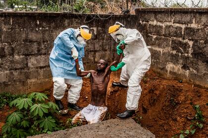 Ganadora del primer premio en la categoría General News Stories, muestra a personal médico atendiendo a una víctima del ébola en Sierra Leona, en noviembre de 2014.
