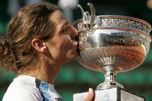Gastón Gaudio besa el trofeo después de ganar la final masculina del torneo de tenis del Abierto de Francia contra su compatriota Guillermo Coria en el estadio Roland Garros en París el 6 de junio de 2004.