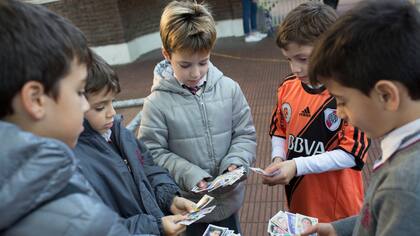Gastón, Pablo, Bautista, Tomás y Juan en medio del ritual que repiten todos los días: cambiar figuritas