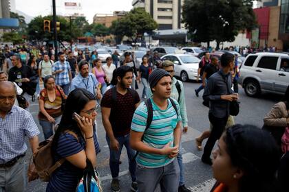 Gente camina en la calle durante un apagón en Caracas, Venezuela.