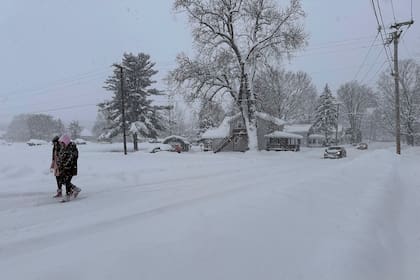 Gente camina entre la nieve el domingo 1 de diciembre de 2024 en Lowville, Nueva York. (AP Foto/Cara Anna)