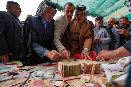 Gente dona dinero en apoyo de Irán y Líbano el vienes 27 de marzo en Babilonia, Irak