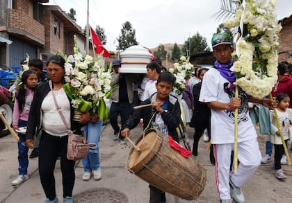 Gente en el cortejo fúnebre de Clemer Rojas, de 23 años, fallecido durante las protestas contra la presidenta Dina Boluarte, en Ayacucho, Perú, el sábado 17 de diciembre de 2022.  Nueve personas han muerto en Ayacucho de un total de 22 en varias partes del país en menos de una semana desde que empezaron las protestas. (AP Foto/Franklin Briceño)