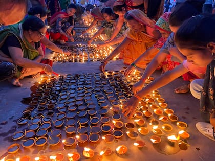 Gente encendiendo lámparas a las orillas del río Saryu en Ayodhya, India durante las celebraciones de Diwali, el festival indio de la luz (AP Foto/Rajesh Kumar Singh)