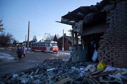 Gente pasando junto a una casa dañada por lo que autoridades rusas en Donetsk dijeron que había sido un ataque ucraniano en Donetsk, en la región de Donetsk controlada por Rusia, en el este de Ucrania, el martes 10 de enero de 2023. (AP Foto)
