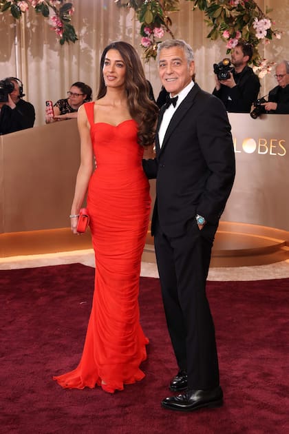 George Clooney, nominado a mejor actor por su papel en Jay Kelly, desparramó encanto con un esmoquin negro de Giorgio Armani. Junto a él su esposa, Amal Clooney, se destacó con un vestido rojo de Balmain con un escote corazón