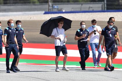 George Russell, del equipo Williams, camina por el circuito con un paraguas