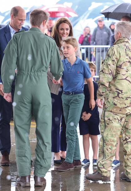 George se da la mano con un instructor aéreo en la misma visita, acompañado por sus padres, los príncipes de Gales.