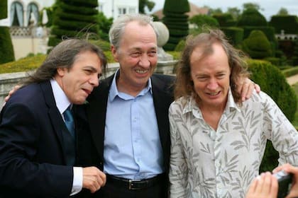 George Young, rodeado por sus hermanos Malcolm y Angus. Produjo los primeros discos de AC/DC