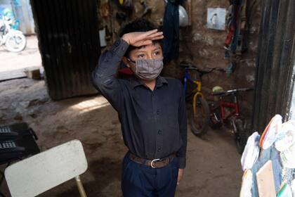 Oscar Rojas, de 11 años, saluda a su maestro