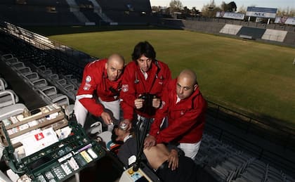 El doctor Eduardo Isern (centro), junto con integrantes de su equipo, practica el uso de un desfibrilador cardíaco en el estadio de Quilmes