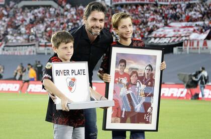 Germán Lux, con sus hijos y la plaqueta que le entregaron los dirigentes de River tras su retiro del fútbol.