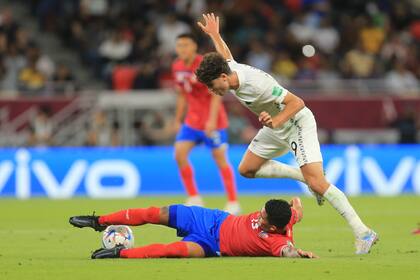 Gerson Torres, de Costa Rica, defiende la pelota desde el suelo ante el avance del neozelandés Matthew Garbett