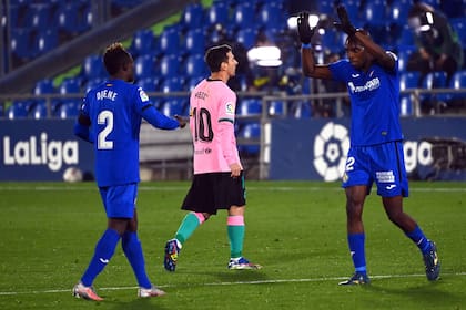 Messi, entre Djene y Nyom, dos de los jugadores de Getafe que le hicieron sentir una marca rigurosa.
