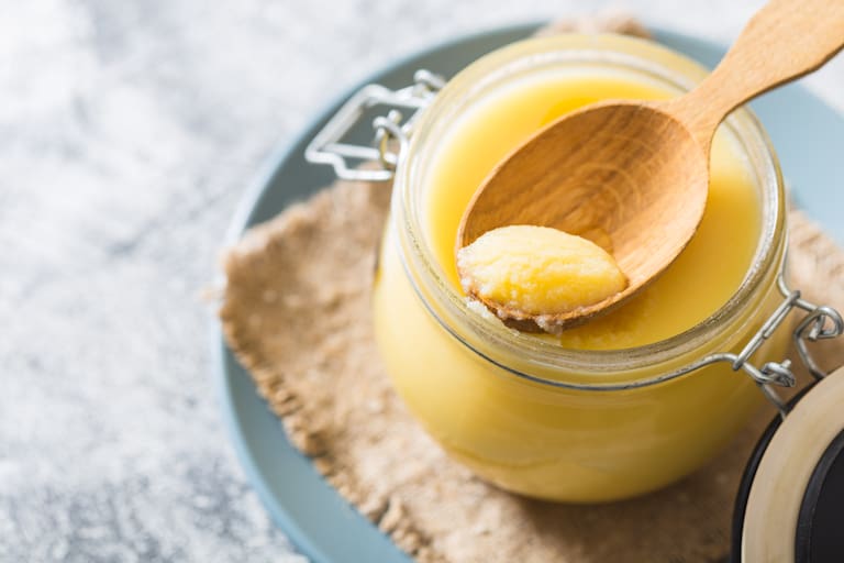 Ghee,Or,Clarified,Butter,In,Jar,And,Wooden,Spoon,On