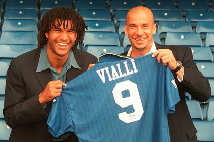 Gianluca Vialli, a la derecha, sostiene la camiseta de su equipo junto a su nuevo entrenador Ruud Gullit en el estadio de del Chelsea, el 17 de junio de 1996, cuando el italiano firmó con el club inglés 
