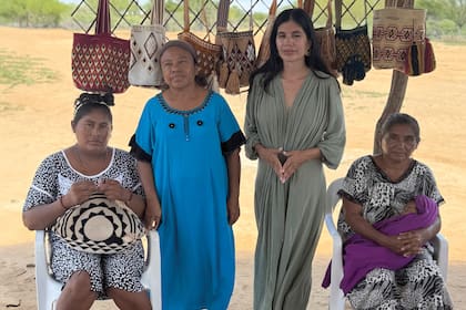 Gina posa frente a las artesanías hechas por la comunidad wayuú.