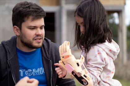 Gino Tubaro con una niña que tiene una prótesis en tres dimensiones