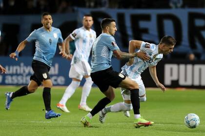 Giovani Lo Celso pierde la pelota presionado por el uruguayo Matias Vecino; la línea de volantes argentinos casi no tuvo juego durante el primer tiempo. (Raúl Martínez/Pool Via AP)