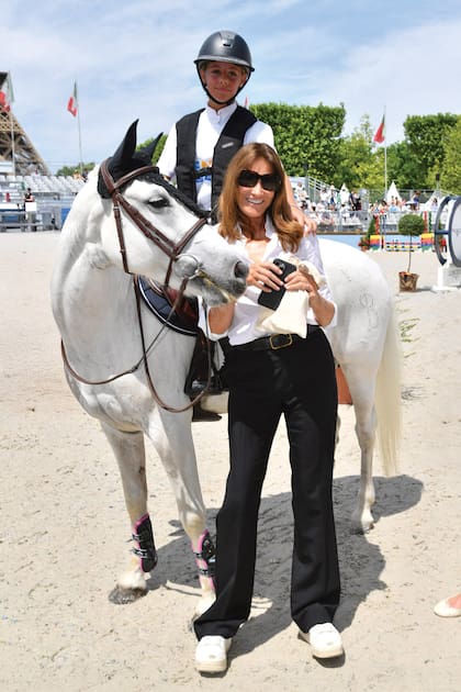 Giulia posa junto a su mamá Carla, quien eligió para ese día un look informal de camisa y zapatillas blancas y pantalón recto negro.