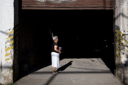 Gladys Torres, de 72 años, intenta compartir su mensaje en un taller mecánico