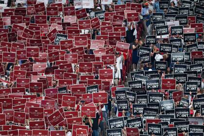 GLENDALE, ARIZONA - SEPTEMBER 21: Attendees hold up signs at the memorial service for political activist Charlie Kirk at State Farm Stadium on September 21, 2025 in Glendale, Arizona. Kirk, the CEO and co-founder of Turning Point USA, was shot and killed on September 10th while speaking at an event during his "American Comeback Tour" at Utah Valley University. Eric Thayer/Getty Images/AFP (Photo by Eric Thayer / GETTY IMAGES NORTH AMERICA / Getty Images via AFP)