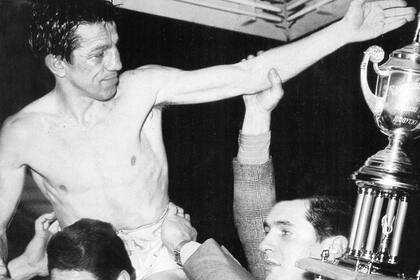 Gloria en 1965. Ringo Bonavena alza al campeón Horacio Accavallo. Con la copa, Tito Lectoure.