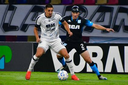 Goleadores en la noche santiagueña: Favio Cabral protege la pelota delante de Agustín García Basso; el delantero abrió el tanteador y el defensor lo cerró.