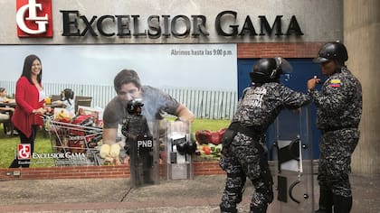 Dos policías vigilan la entrada del supermercado Excelsior Gama en Caracas