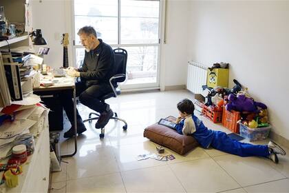 Gonzalo Fuertes, y su hijo Francisco, de 7 años, cada uno con su dispositivo en su casa