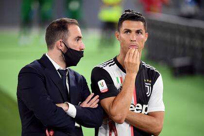 Gonzaló Higuaín, ausente por una lesión, conversa con Cristiano Ronaldo tras el final del partido