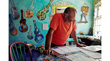 Gonzalo mirando bosquejos en la cocina que es también su estudio.