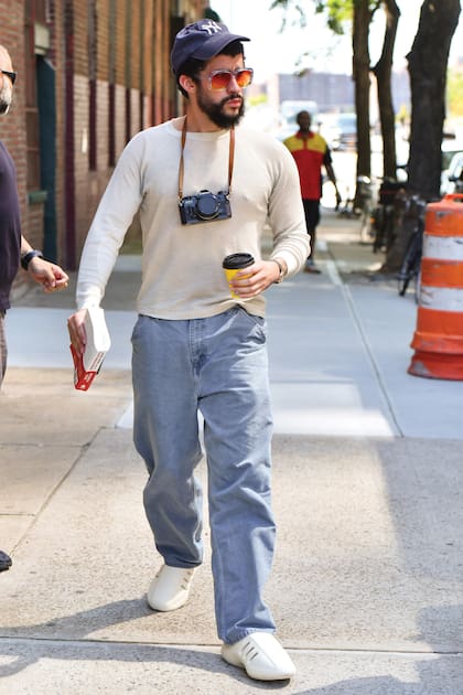 Gorra de los Yankees y café en mano, con un look de turista en NUEVAYoL –así es el nombre del tema que lanzó en julio de 2025 y que rinde homenaje a la cultura puertorriqueña en Nueva York mezclando salsa y dembow. Esta fue tomada en 2024, cuando el artista llegaba al estudio de Brooklyn