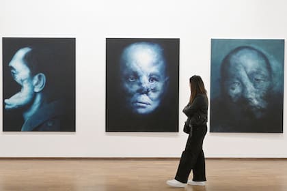 Un visitante observa las pinturas "Justo 1, 2 y 3"