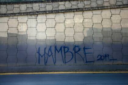 Graffiti en el que se lee "Hambre 2019" y que cubre un muro de la autopista en Caracas, Venezuela, el 27 de enero