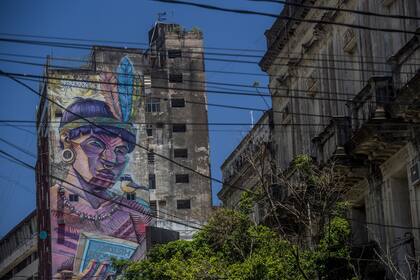 Grafiti en Asunción de un indígena que lee un libro en inglés