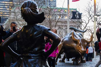 Gran cantidad de turistas fotografían a ''''La niña sin miedo'''' enfrentada al Toro de Wall Street, en Nueva York