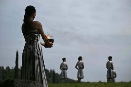 Greek actress Mary Mina, playing the role of the High Priestess, holds the Olympic flame during the Olympic torch lighting ceremony for the Paris 2024 Olympics Games at the Ancient Olympia archeological site, birthplace of the ancient Olympics in southern Greece, on April 16, 2024. (Photo by Aris MESSINIS / AFP)�