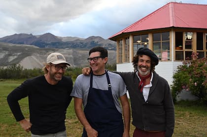 Gregorio Cramer y su socio Alejandro Azpiazu rodean al cocinero Willy Muscardit, quien está a cargo de las delicias que se sirven en Lagos del Furioso