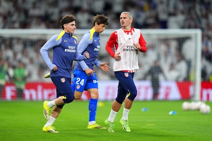 Griezmann (en la foto haciendo la entrada en calor junto a Julián Álvarez) pudo haber jugado este domingo su último derby contra Real Madrid