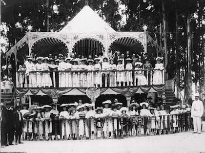 Grupo de niñas, hombres y mujeres durante una celebración en un kiosco en La Plata.