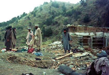 Grupos de talibanes en el destruido campamento de Khost, en Afganistán