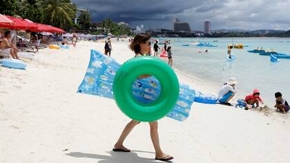 Turistas disfrutando del mar en Tumon, un distrito turístico de la isla de Guam