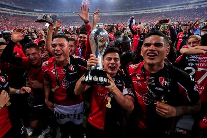 GUADALAJARA, MEXICO - DECEMBER 12: Aldo Rocha of Atlas holds the trophy and celebrates with teammates after winning the final second leg match between Atlas and Leon as part of the Torneo Grita Mexico A21 Liga MX at Jalisco Stadium on December 12, 2021 in Guadalajara, Mexico. (Photo by Refugio Ruiz/Getty Images)