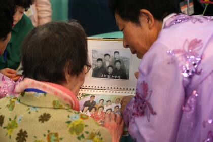 La surcoreana Han Shin-ja de 99 años mira fotografías junto a su hija de 672 años que vino de Corea del Norte