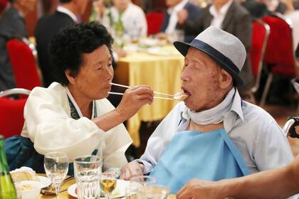 La norcoreana Ahn Jong Sun de 70 años alimenta a su padre surcoreano Ahn Jong-ho de 100 años