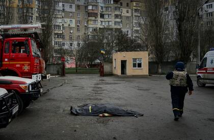 Un bombero pasa junto al cadáver de un compañero muerto por el ataque ruso de la estación de bomberos en Kherson, Ucrania, en la víspera de Navidad ortodoxa.