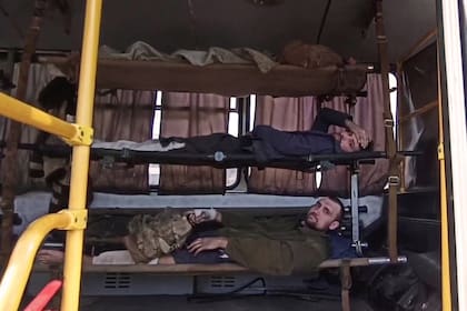 Miembros del servicio ucraniano acostados en camillas en un vehículo mientras se preparan para ser escoltados por personal militar prorruso después de salir de la planta siderúrgica Azovstal sitiada en Mariupol