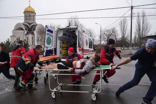 Paramédicos de ambulancias trasladan a un hombre herido en una camilla, herido por bombardeos en una zona residencial, en el hospital de maternidad convertido en sala médica y utilizado como refugio antiaéreo en Mariupol, Ucrania